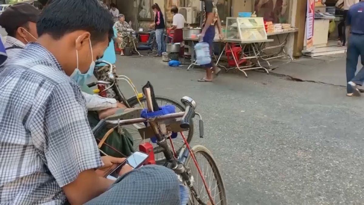 Un ciudadano birmano mira su teléfono móvil