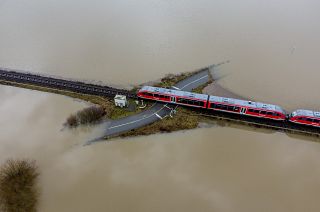 A train passes a railway crossing that is surrounded by flooding caused by rain and melting snow in Nidderau near Frankfurt, Germany. February 3, 2021