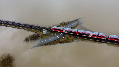 A train passes a railway crossing that is surrounded by flooding caused by rain and melting snow in Nidderau near Frankfurt, Germany. February 3, 2021