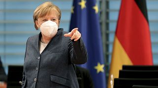German Chancellor Angela Merkel points as she arrives for the weekly cabinet meeting at the Chancellery in Berlin, Germany, Wednesday, Feb. 3, 2021.
