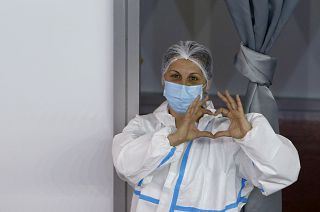 Mitarbeiterin einer Impfstation in Belgrad macht ein Herzzeichen.