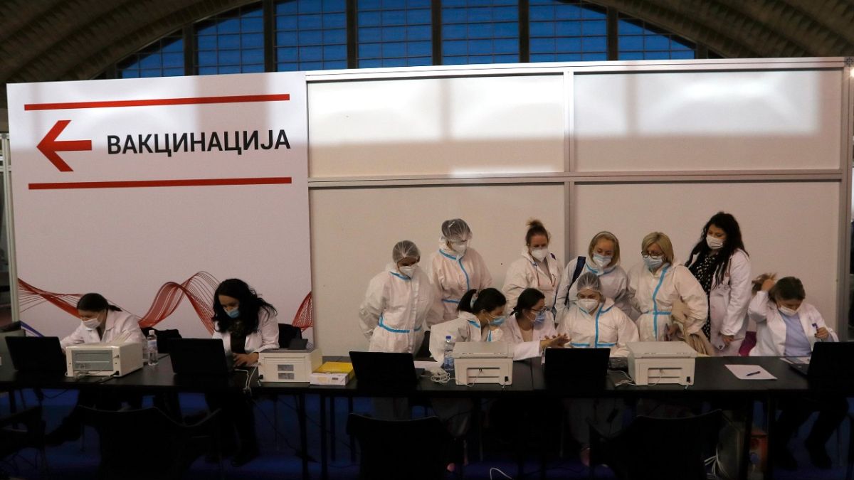 عاملون طبيون يرتدون معدات واقية يستعدون للتلقيح في مركز التطعيم المؤقت في بلغراد  25 يناير 2021