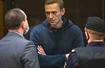 Opposition leader Alexei Navalny talks to one of his lawyers, left, before being sentenced to 3.5 years in prison