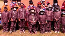 شاهد: التلاميذ في بوليفيا يرتدون بذلات تحمي من الأجسام البيولوجية للذهاب إلى المدارس
