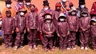 Bolivian students wear protective suits, masks