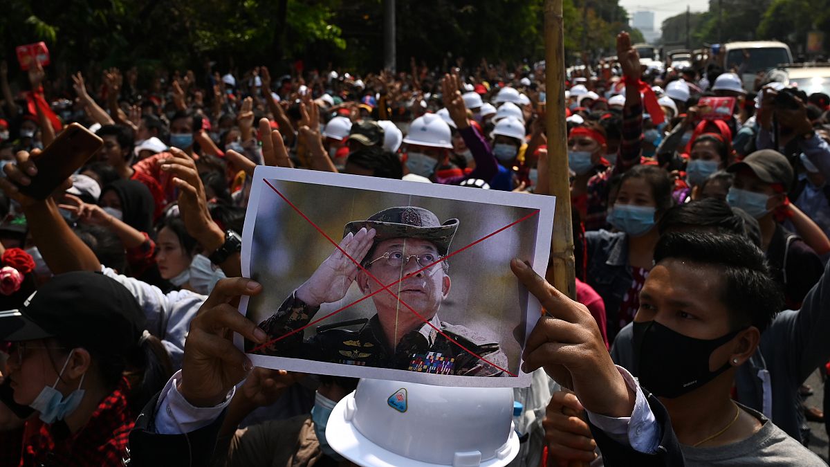 متظاهر يحمل لافتة تندد بالقائد العسكري لميانمار الجنرال مين أونغ هلاينغ خلال مظاهرة ضد الانقلاب العسكري في يانغون في 6 فبراير 2021