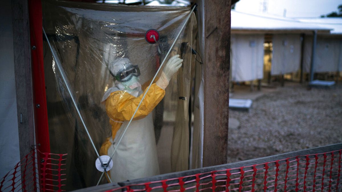 In this Saturday, July 13, 2019, file photo, a health worker wearing protective suit enters an isolation pod to treat a patient at a treatment center in Beni, Congo DRC. 