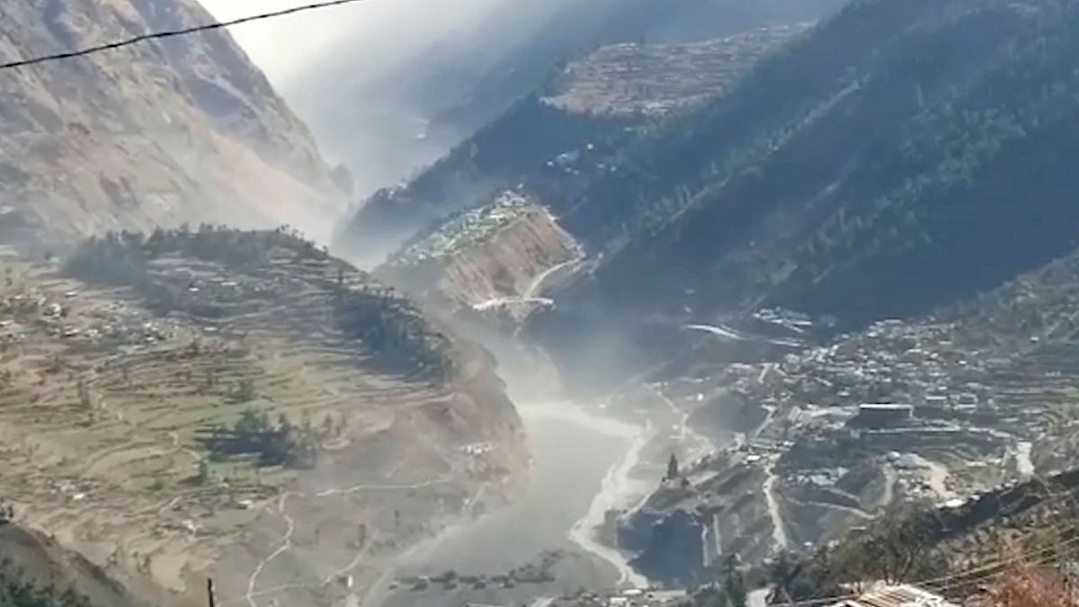 A still from video provided shows a massive flood of water, mud and debris flowing at Chamoli District