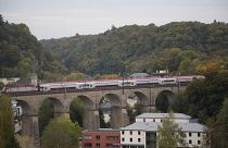 A train passes over a stone bridge in Luxembourg.