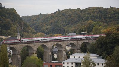 A train passes over a stone bridge in Luxembourg. 