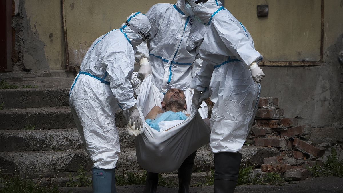 In this June 3, 2020 photo, medical workers carry a patient at infectious diseases hospital where patients with coronavirus are treated in St.Petersburg, Russia. 
