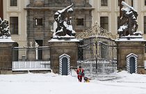 A worker cleans off snow in front of the Prague Castle after a heavy snowfall in Prague, Czech Republic.