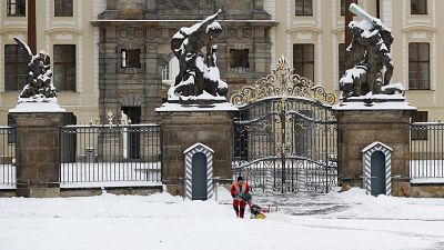 A worker cleans off snow in front of the Prague Castle after a heavy snowfall in Prague, Czech Republic. 