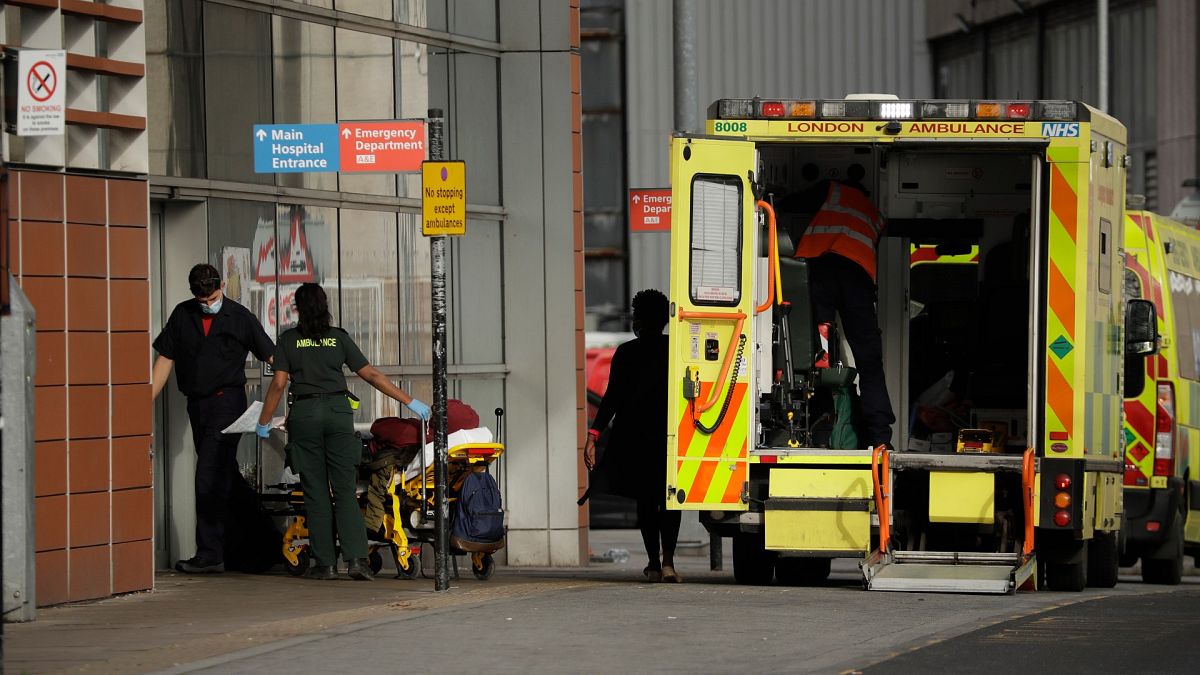 A patient is wheeled in on a trolley after arriving in an ambulance outside the Royal London Hospital in east London, Thursday, Feb. 4, 2021.
