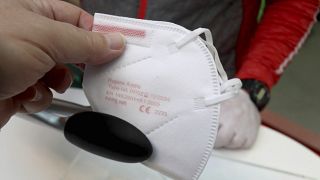 An Austrian citizen receives an FFP2 protective mask in a supermarket.
