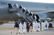 Un grupo de migrantes sube el avión del Ejército chileno en el que han sido deportados.