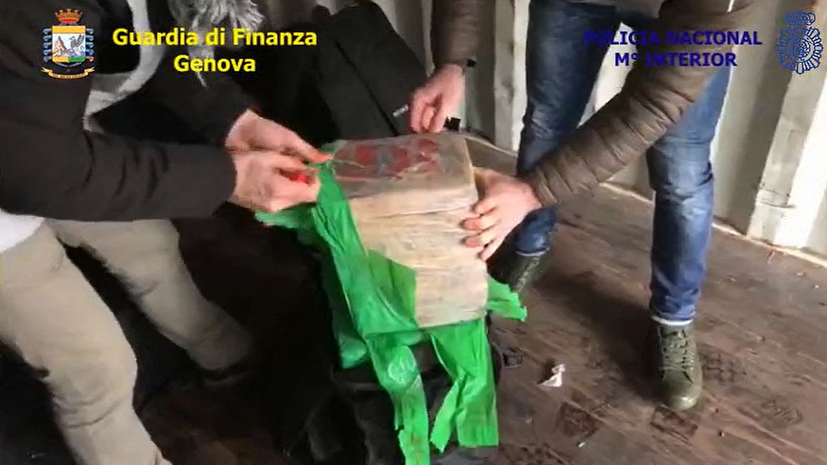 ضباط الشرطة الإيطالية يفتحون حقيبة مليئة بعبوات الكوكايين- أرشيف