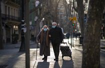Una pareja con mascarillas camina por un bulevar en Barcelona, España, el 27 de enero de 2021.