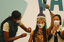 Brezilya'da geleneksel olarak giyinmiş Witoto kabilesi üyesi yerli bir kadın aşı yaptırırken.