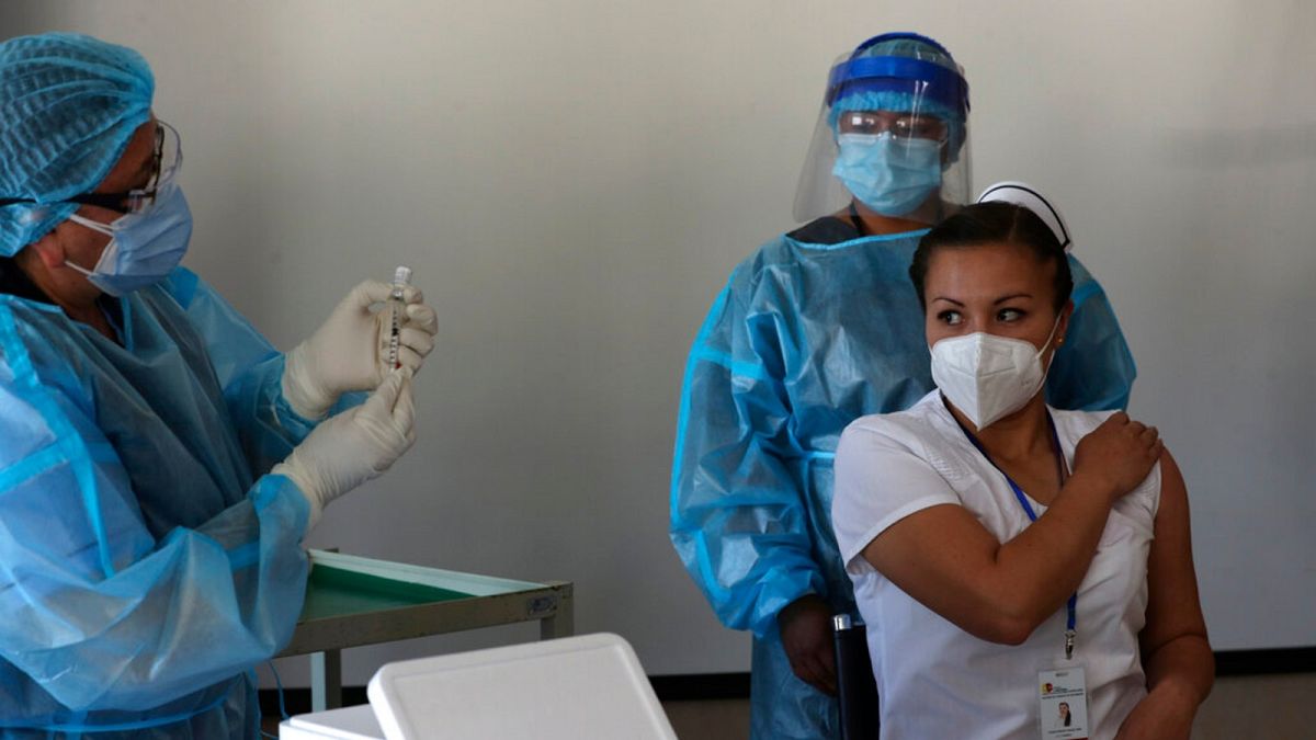 Nurse Cristina Chango receives her first dose of the Pfizer-BioNtech vaccine against COVID-19 at the Pablo Arturo Suarez Hospital in Quito, Ecuador, Thursday, Jan. 21, 2021. 