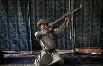 In this July 27, 2018, file photo, Kahlan, a 12-year-old former child soldier with Yemen's Houthi rebels, demonstrates how to use a weapon at a camp for displaced persons