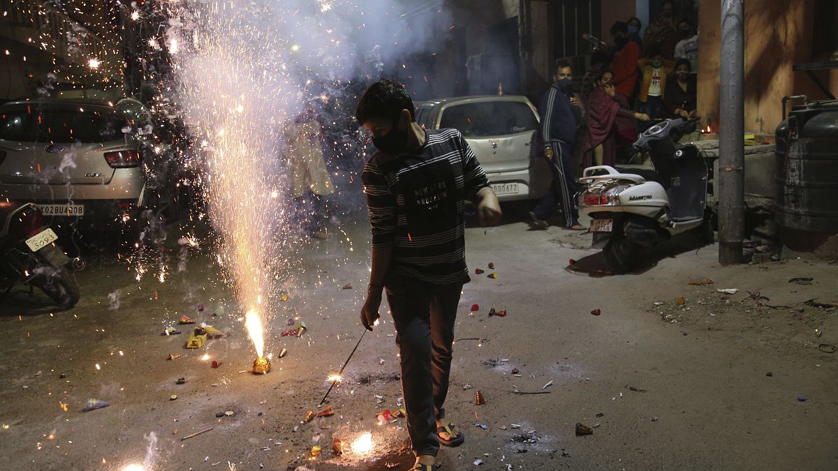 A boy plays with fireworks during Diwali, the Hindu festival of lights, in Jammu, India Saturday, Nov. 14, 2020. 