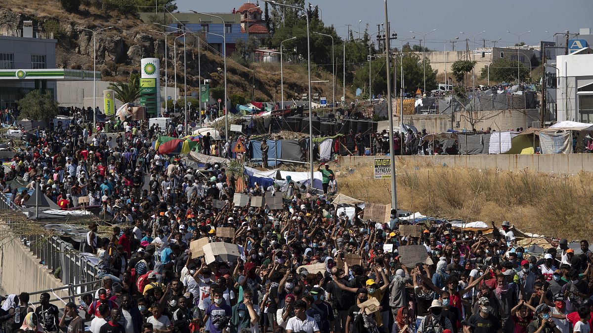 مهاجرون يشاركون في مسيرة بالقرب من مدينة ميتيليني ، في شمال شرق جزيرة ليسبوس، اليونان.