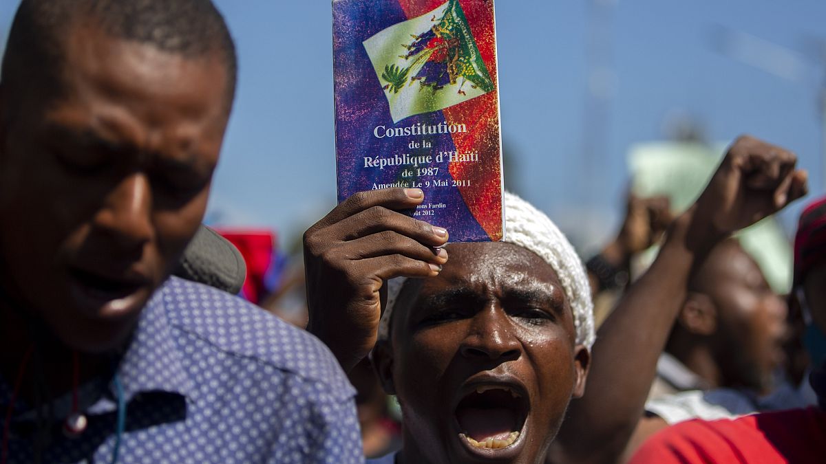 Un manifestante sostiene una copia de la constitución haitiana durante una protesta para exigir la dimisión de Jovenel Moise en Puerto Príncipe, el 10 de febrero de 2021