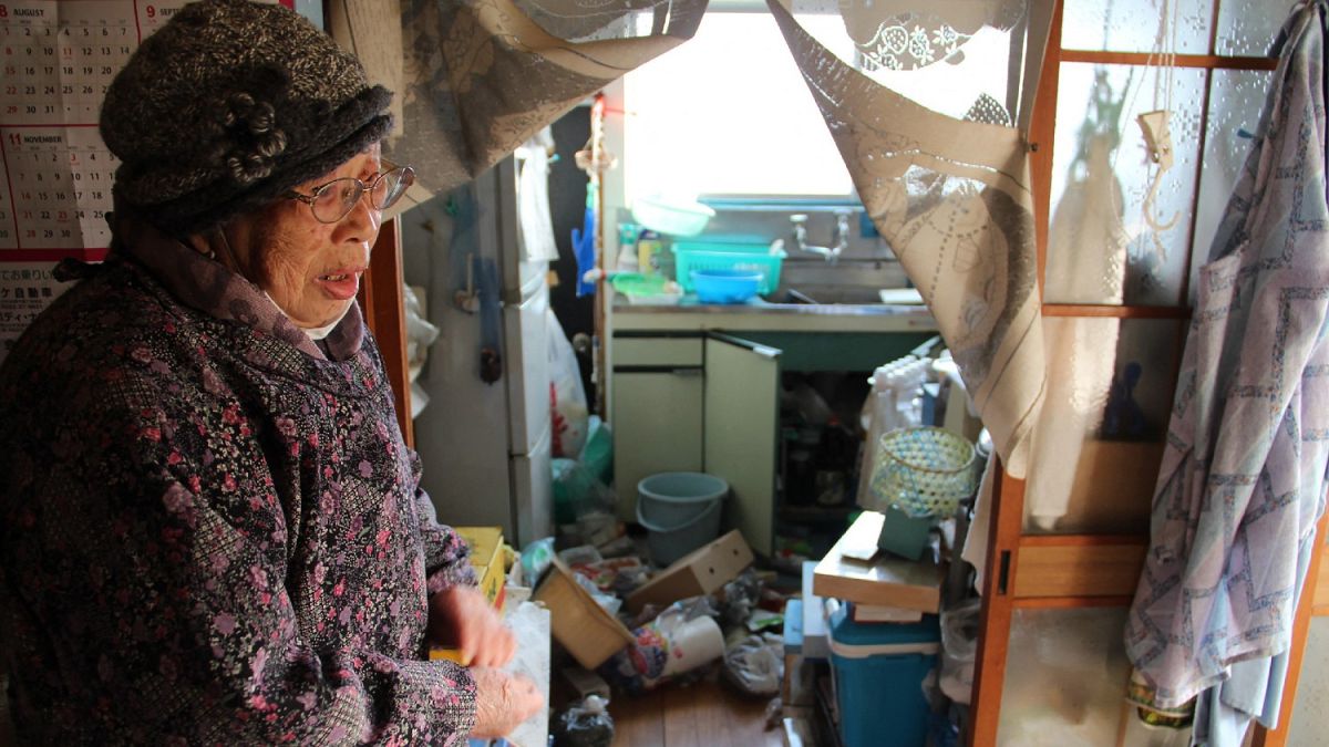 امرأة يابانية تقف في مطبخها المتناثر إثر الزلزال، فوكوشيما 14 فبراير 2021
