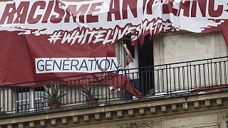 ¨Ανδρας έχει μόλις σκίσει πανό που είχαν αναρτήσει μέλη της γαλλικής ακροδεξιάς οργάνωσης Génération identitaire με το σύνθημα #White_Lives_Matter (αρχείο).