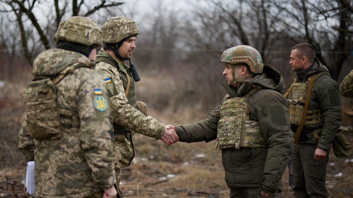 الرئيس الأوكراني فولوديمير زيلينسكي يصافح جنديًا أثناء زيارته لمنطقة دونيتسك التي دمرتها الحرب 11 فبراير 2021