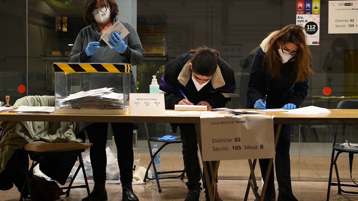 Officials recount postal vote's ballots after closing a polling station in the Ninot market in Barcelona during regional elections in Catalonia on February 14, 2021.