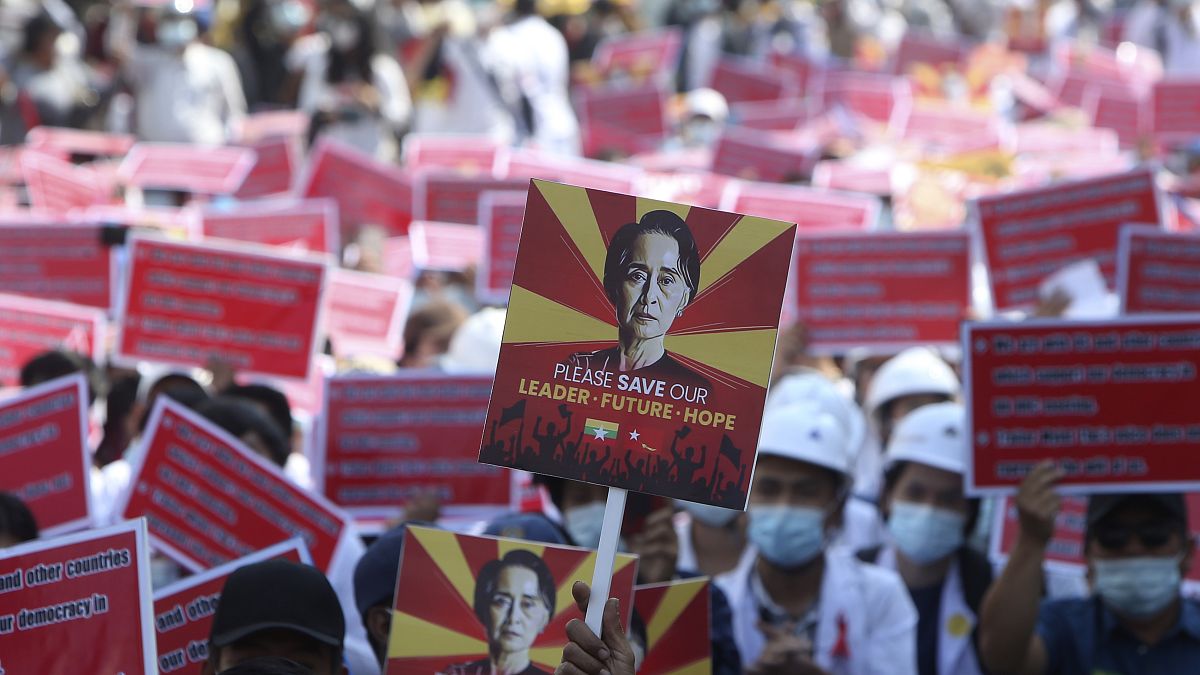 A protester holds up a placard with an image of deposed leader Aung San Suu Kyi during an anti-coup rally in front of the Mandalay railway station in Myanmar. Feb. 15, 2021.