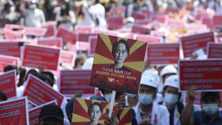 A protester holds up a placard with an image of deposed leader Aung San Suu Kyi during an anti-coup rally in front of the Mandalay railway station in Myanmar. Feb. 15, 2021.