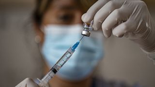 Una enfermera prepara una dosis de la vacuna cnotra la COVID-19