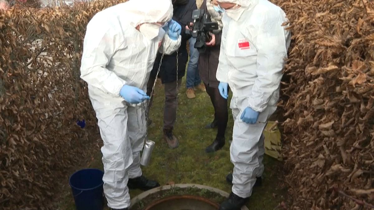 Bomberos franceses toman una muestra de aguas residuales sumergiendo una canícula en una alcantarilla.