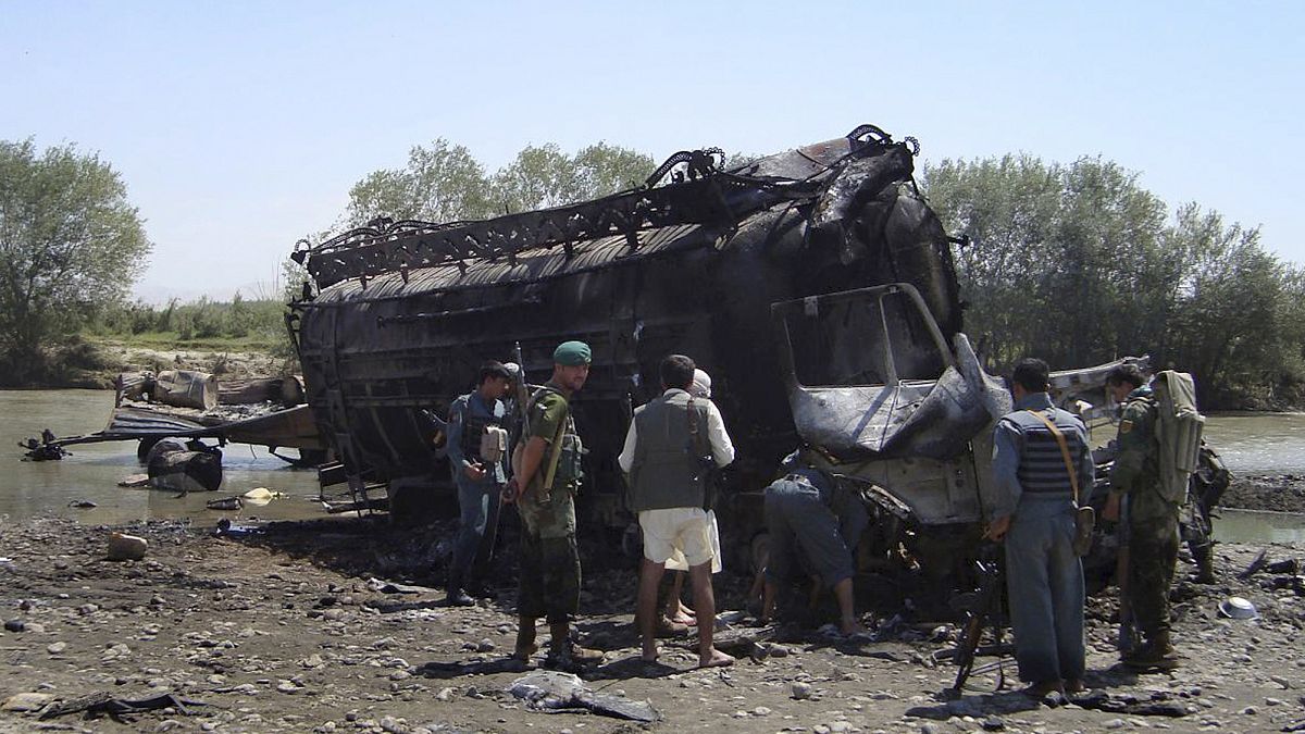 Afghanische Polizisten betrachten einen von zwei verbrannten Tankwagen, in der Nähe von Kunduz, Afghanistan, 04.09.2009