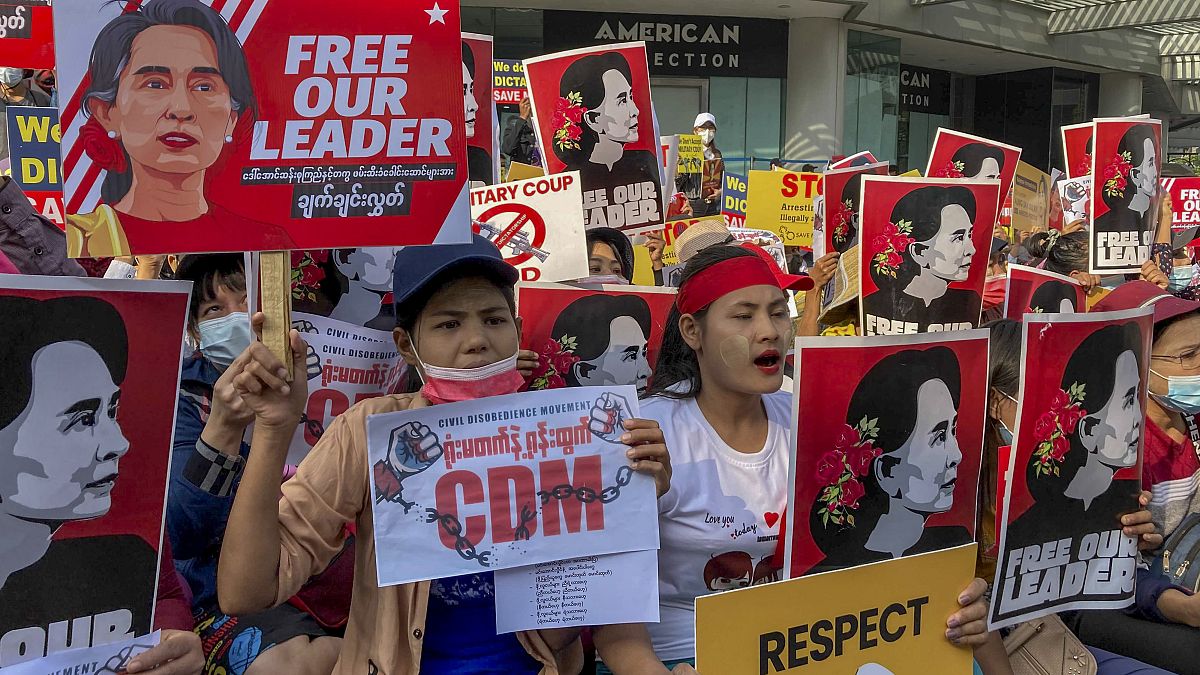 متظاهرون يرفعون صوراً لزعيمة ميانمار المحتجزة أونغ سان سو كي خلال احتجاج على الانقلاب العسكري في يانغون - ميانمار.