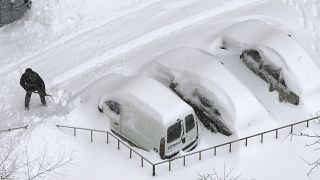 A driver shovels snow off his vehicle in Kiev, Ukraine.
