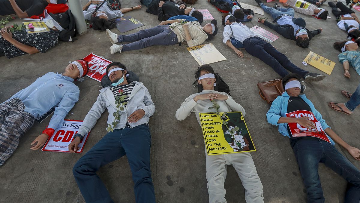 Demonstrators, with eyes blindfolded, lie down in the street to a protest a military coup in Yangon, Myanmar, Tuesday, Feb. 16, 2021. 