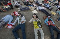 Demonstrators, with eyes blindfolded, lie down in the street to a protest a military coup in Yangon, Myanmar, Tuesday, Feb. 16, 2021. 