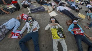 Demonstrators, with eyes blindfolded, lie down in the street to a protest a military coup in Yangon, Myanmar, Tuesday, Feb. 16, 2021. 