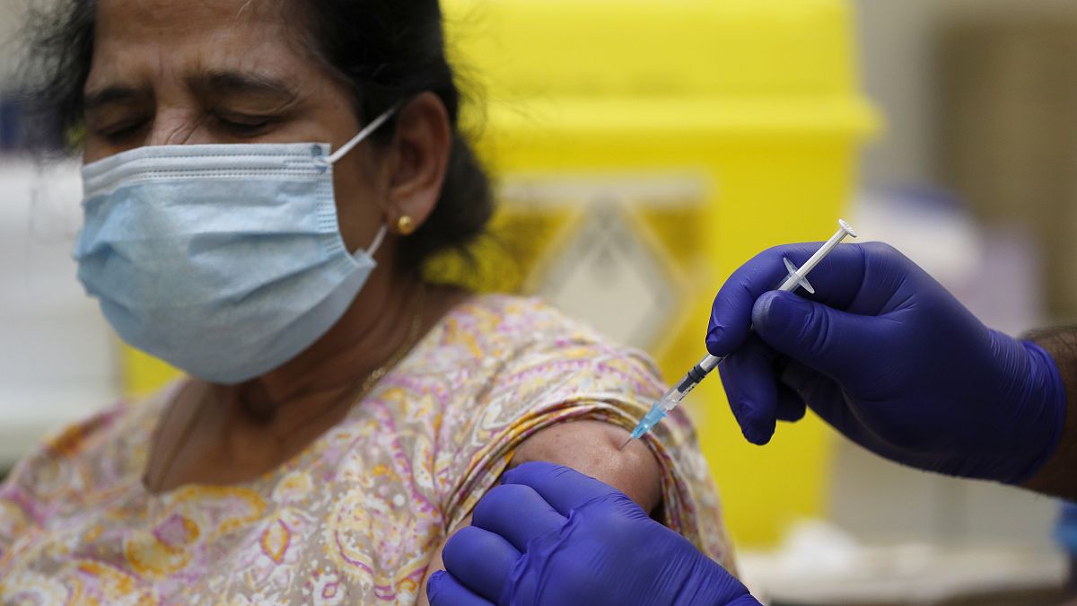 Doctor PJ Suresh injects a patient with the Pfizer/BioNtech COVID-19 vaccine at the Fullwell Cross Medical Centre in Ilford, London, Friday, Jan. 29, 2021.