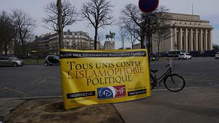 A banner reads « All united against political islamophobia » during a gathering in Paris, Sunday, Feb. 14, 2021.