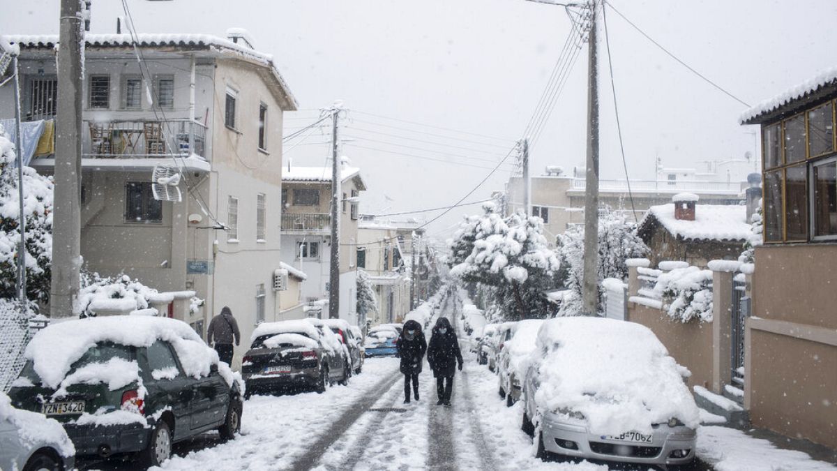 People walk in a street of Petralona neighborhood of Athens