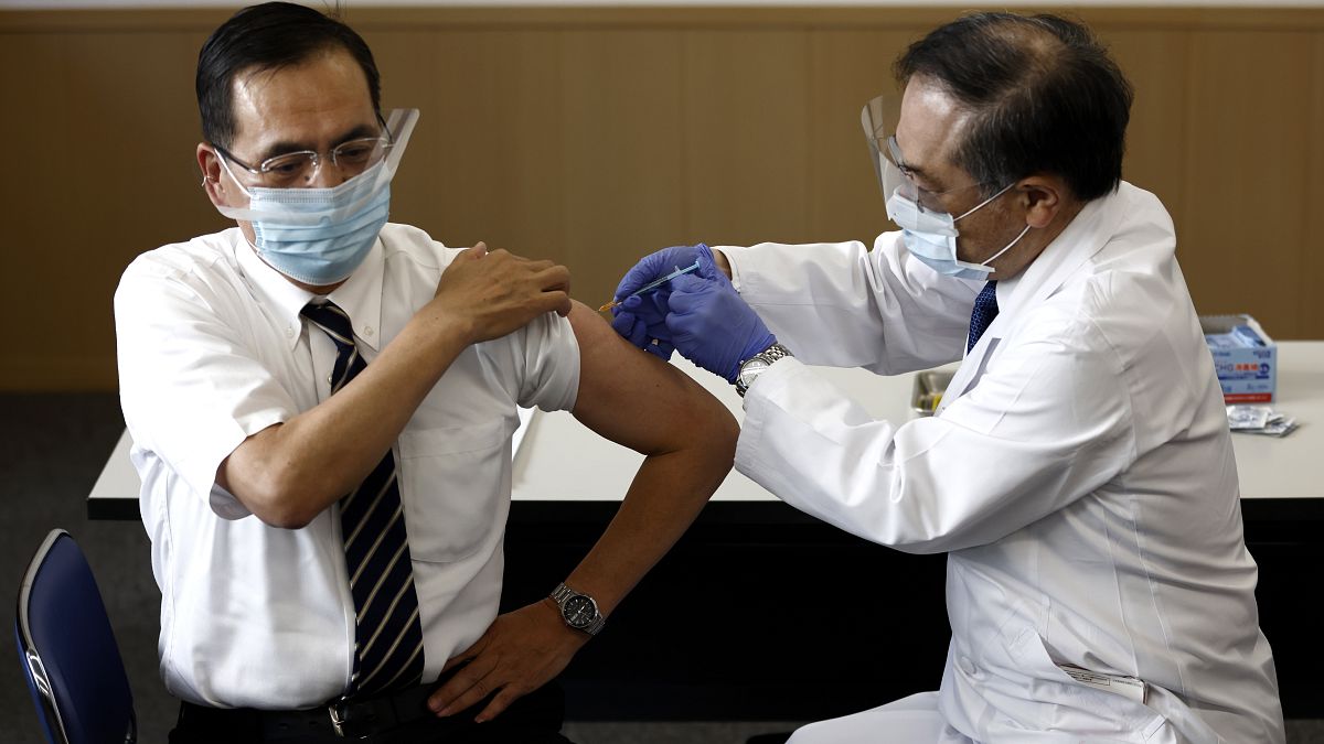 Tokyo Medical Center director Kazuhiro Araki, left, receives a dose of COVID-19 vaccine in Tokyo Wednesday, Feb. 17, 2021.