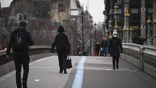La gente lleva mascarillas mientras camina por el puente de Westminster en Londres, el miércoles 3 de febrero de 2021.