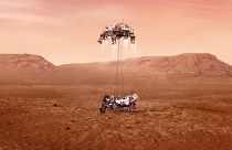 This illustration provided by NASA shows the Perseverance rover, bottom, landing on Mars.