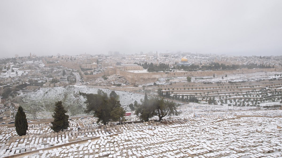 الثلج يغطي جبل الزيتون مع منظر مطل على قبة الصخرة في المسجد الأقضى في القدس. 2021/02/18