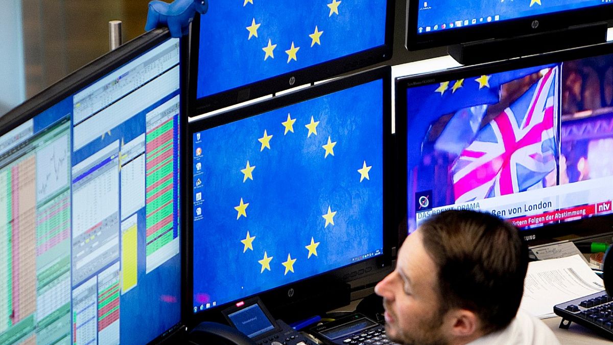 A computer screen shows news about the Brexit as a broker watches his screens at the stock market in Frankfurt, Germany, Wednesday, Jan. 16, 2019.